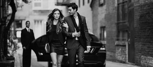 Man and woman walking away from 168一分钟极速赛车官网 limo with chauffeur.